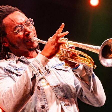 Homme jouant de la trompette en concert.