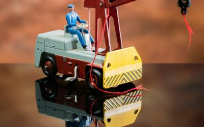 Jouet grue miniature avec opérateur assis.