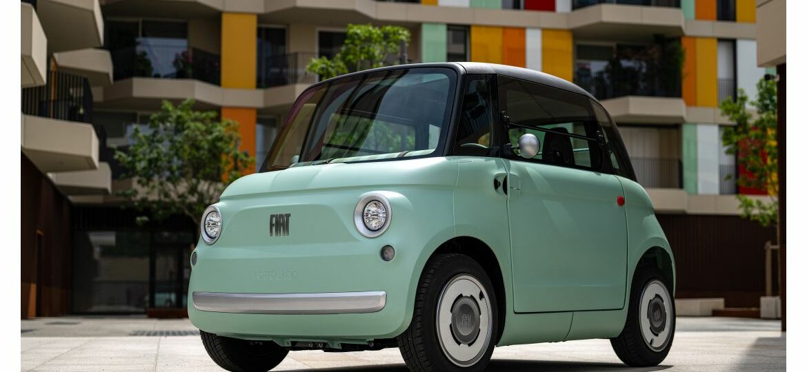 Petite voiture électrique verte, architecture colorée.