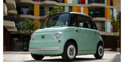 Petite voiture électrique verte, architecture colorée.