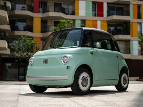 Petite voiture électrique verte, architecture colorée.