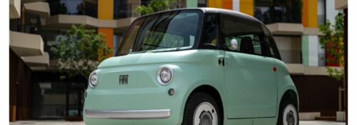 Petite voiture électrique verte, architecture colorée.