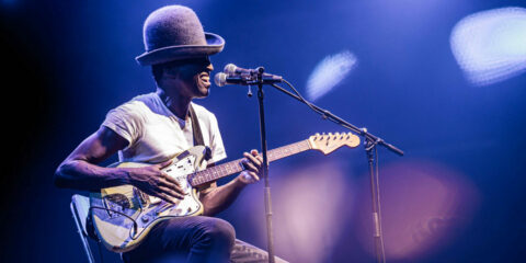 Musicien jouant de la guitare sur scène.