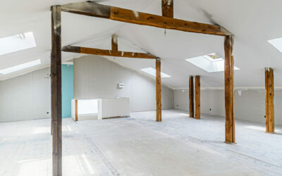 Grenier rénové avec poutres en bois apparentes.