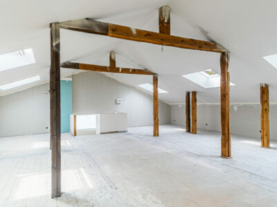 Grenier rénové avec poutres en bois apparentes.