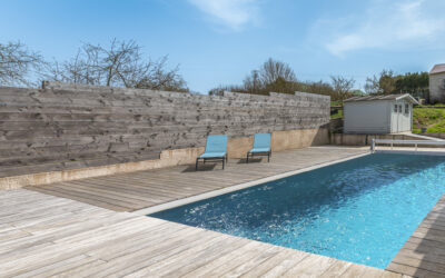 Piscine extérieure avec chaises longues en bois.