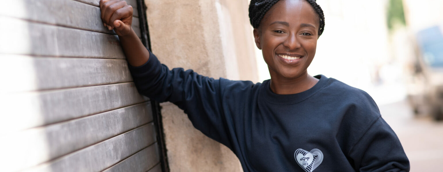 Personne souriante portant un pull noir.