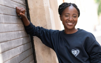 Personne souriante portant un pull noir.