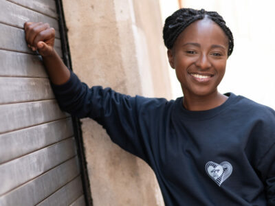 Personne souriante portant un pull noir.