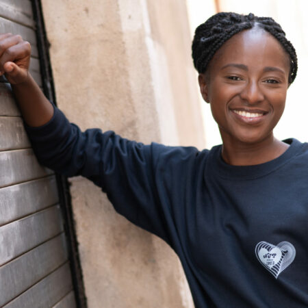 Personne souriante portant un pull noir.
