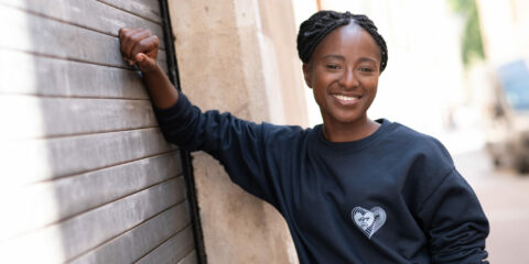 Personne souriante portant un pull noir.