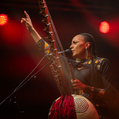 Musicienne jouant de la kora sur scène.