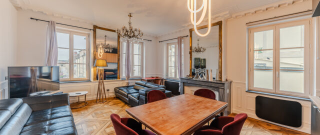 Salon élégant avec parquet et mobilier moderne.