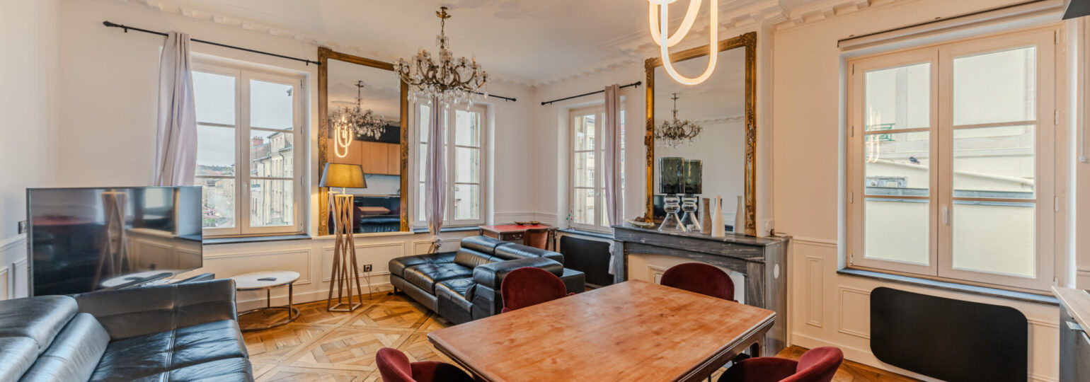 Salon élégant avec parquet et mobilier moderne.