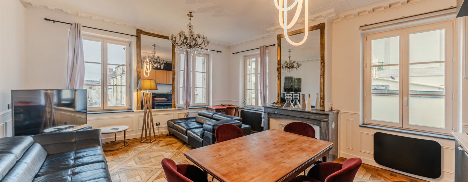Salon élégant avec parquet et mobilier moderne.