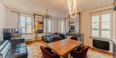 Salon élégant avec parquet et mobilier moderne.