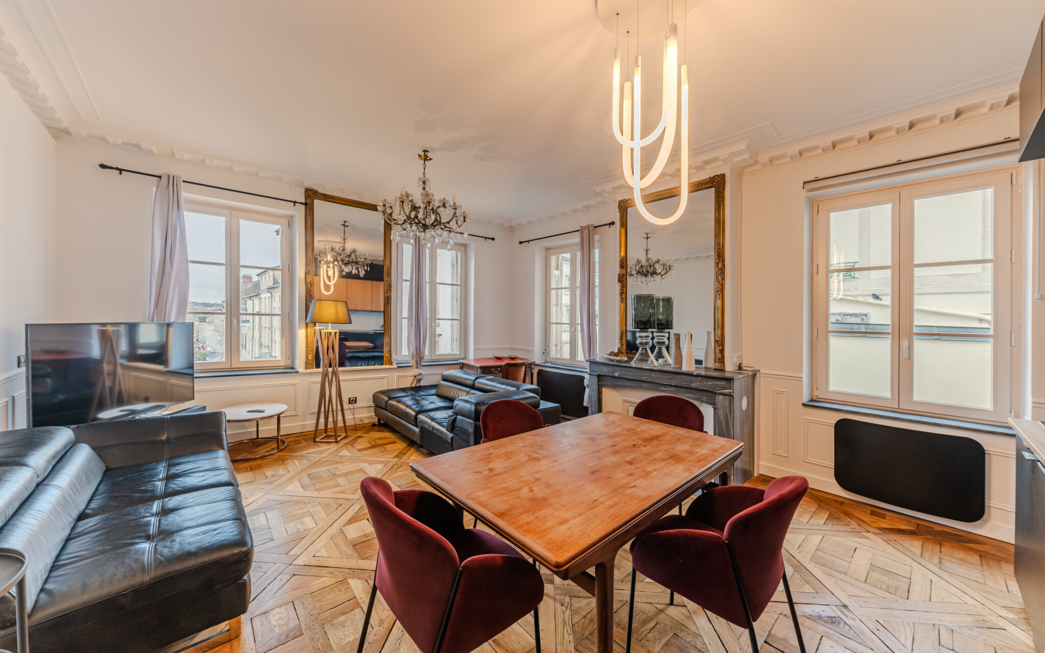 Salon élégant avec parquet et mobilier moderne.