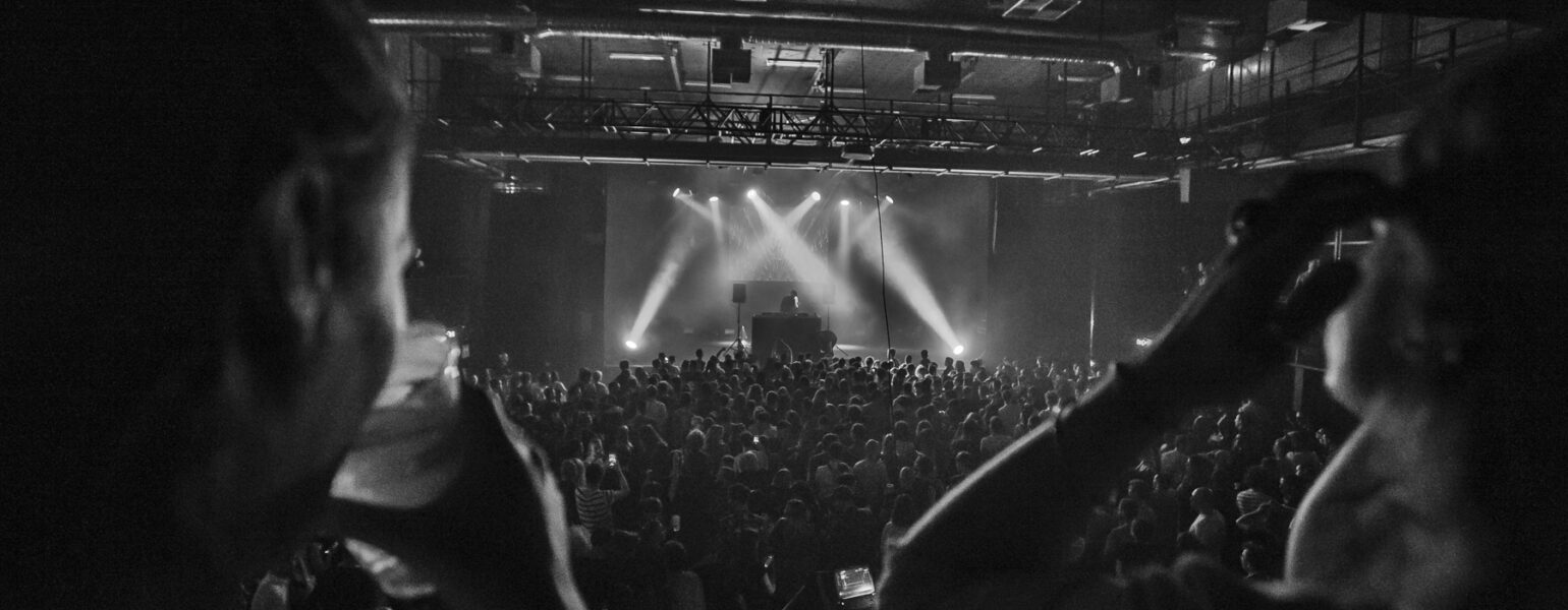 Concert en noir et blanc avec public enthousiaste.