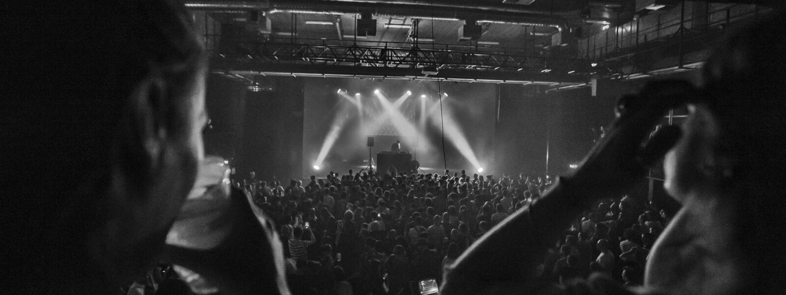 Concert en noir et blanc avec public enthousiaste.