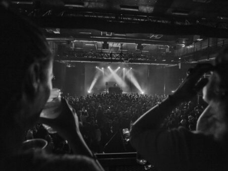Concert en noir et blanc avec public enthousiaste.