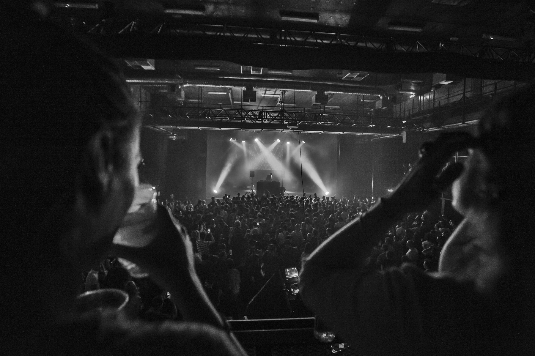 Concert en noir et blanc avec public enthousiaste.