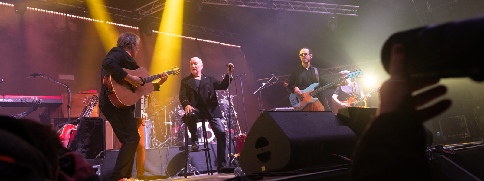 Concert avec groupe jouant sur scène éclairée.