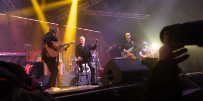 Concert avec groupe jouant sur scène éclairée.