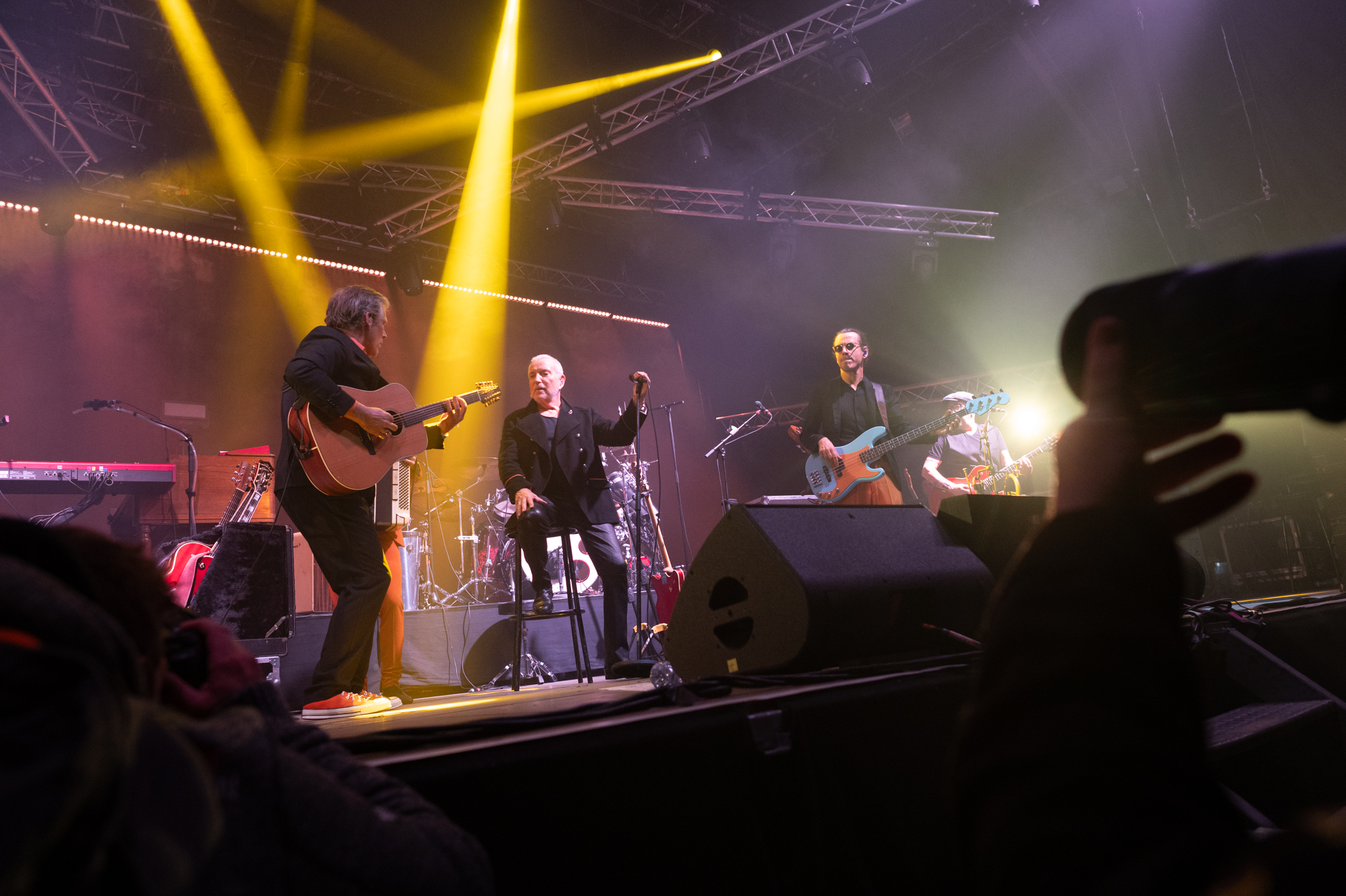 Concert avec groupe jouant sur scène éclairée.