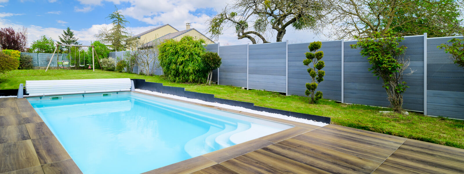 Piscine extérieure avec terrasse en bois.