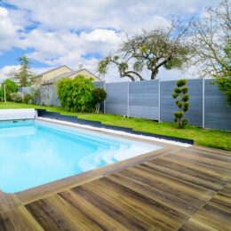 Piscine extérieure avec terrasse en bois.