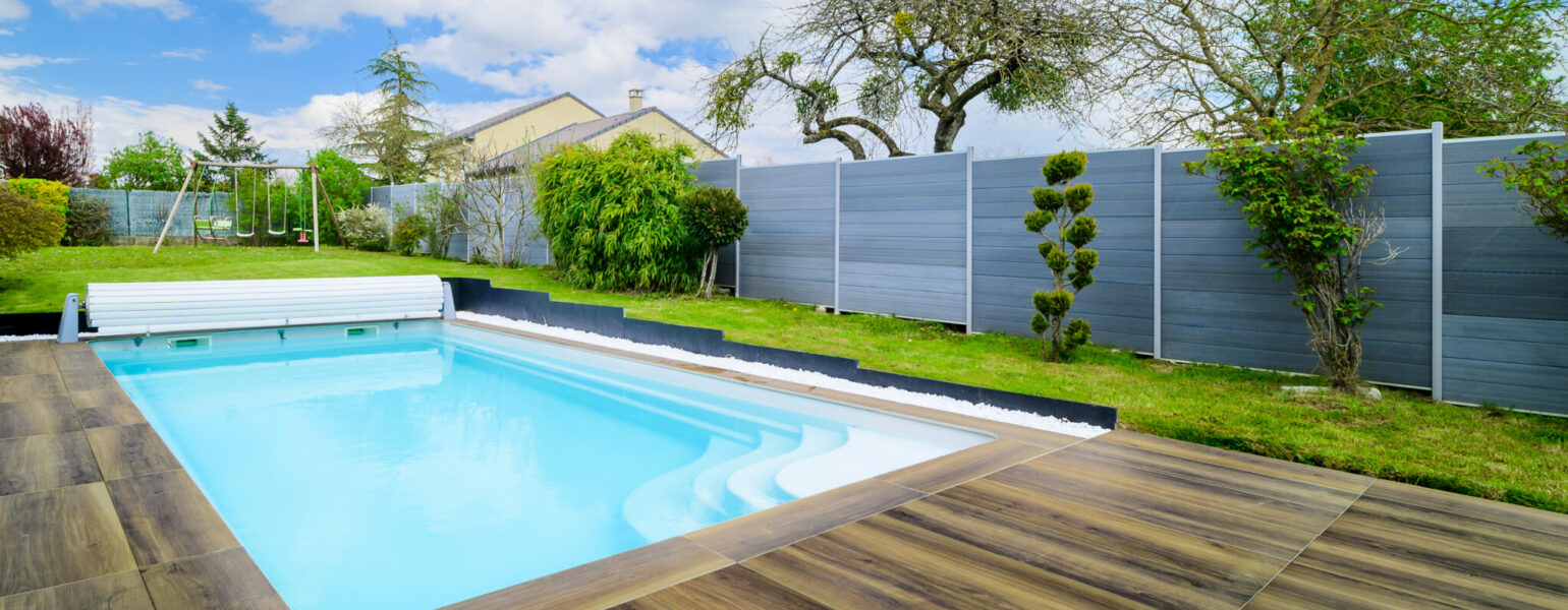 Piscine extérieure avec terrasse en bois.