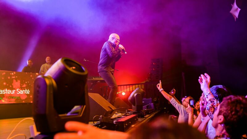 Concert avec chanteur sur scène, public enthousiaste.