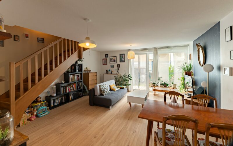 Salon moderne avec escalier en bois et mobilier.