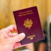 Passeport français tenu en main, valise derrière.