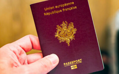 Passeport français tenu en main, valise derrière.