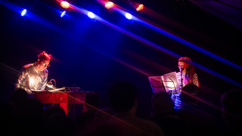 Duo en concert sous lumières colorées sur scène.