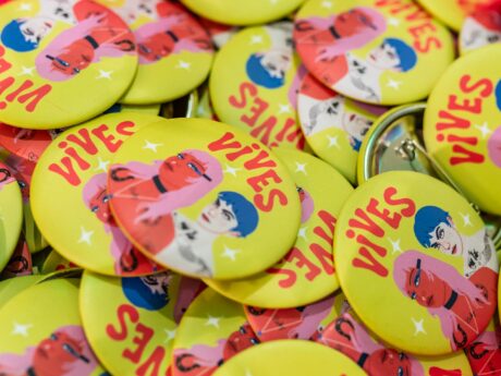 Badge jaune avec illustrations colorées 'Vives'.