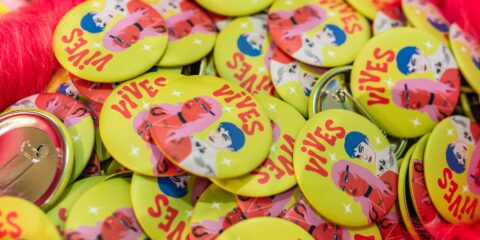 Badge jaune avec illustrations colorées 'Vives'.