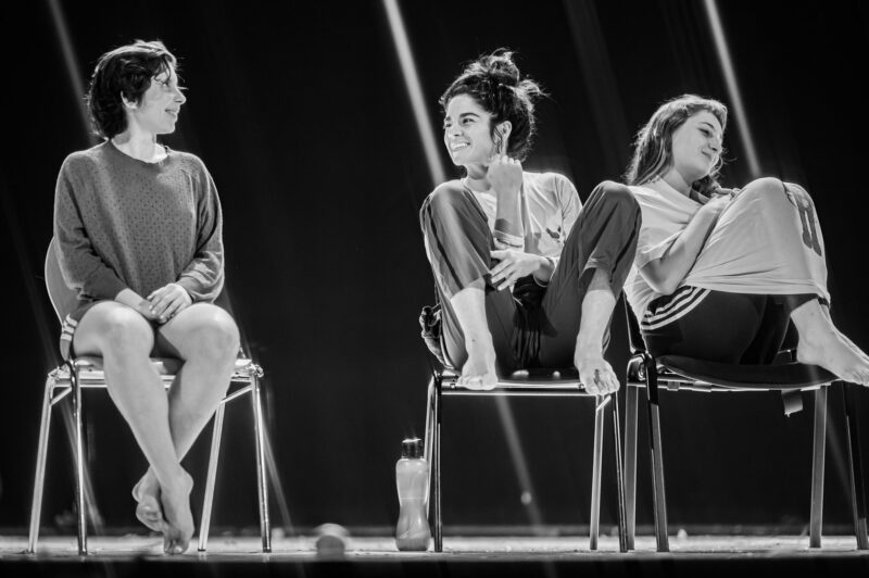 Trois femmes assises sur des chaises, souriant.