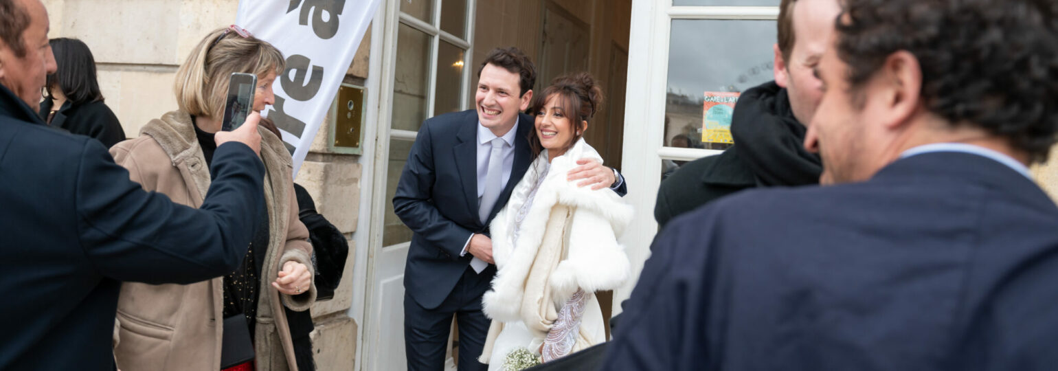 Couple souriant photographié devant une salle.