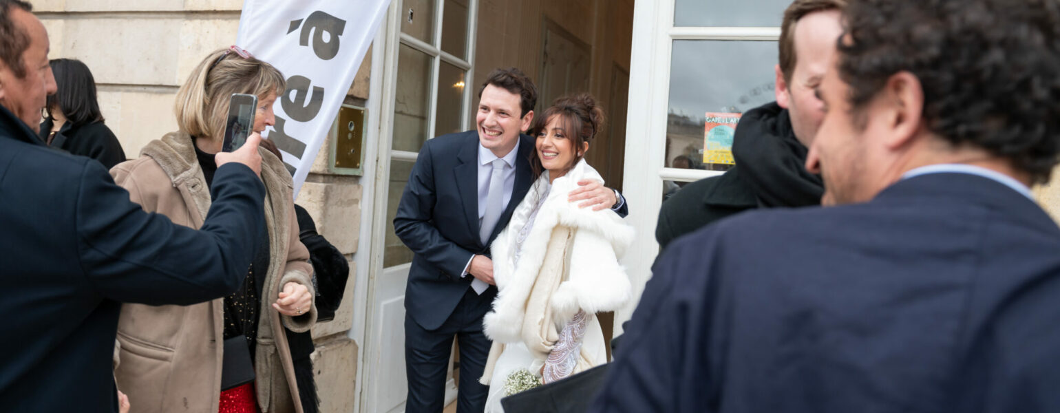 Couple souriant photographié devant une salle.