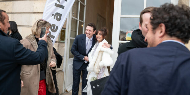 Couple souriant photographié devant une salle.