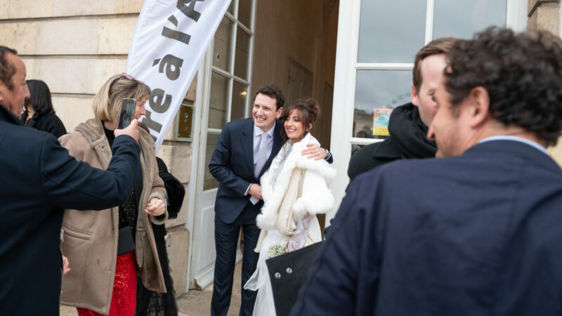 Couple souriant photographié devant une salle.