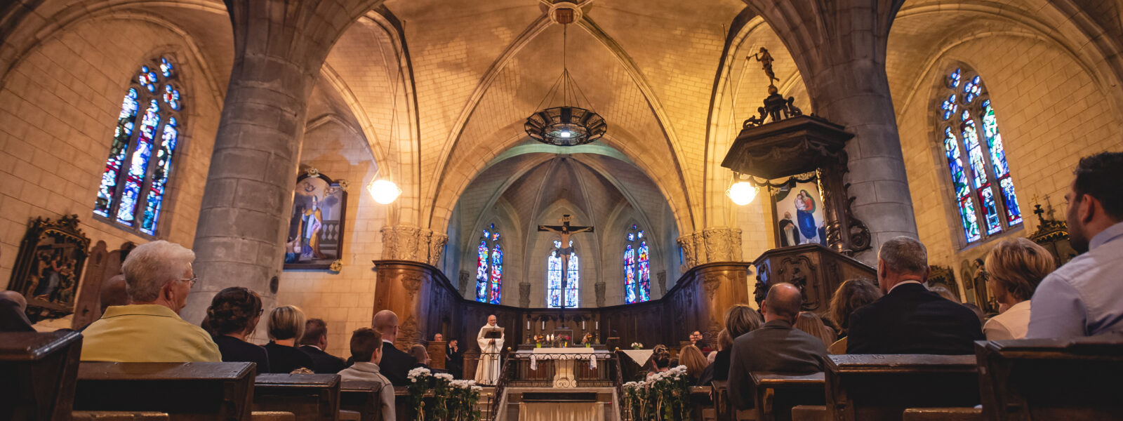 Intérieur d'une église avec fidèles et autel.