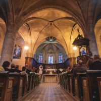Intérieur d'une église avec fidèles et autel.
