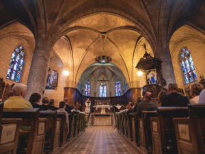 Intérieur d'une église avec fidèles et autel.