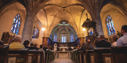 Intérieur d'une église avec fidèles et autel.