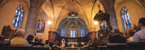 Intérieur d'une église avec fidèles et autel.