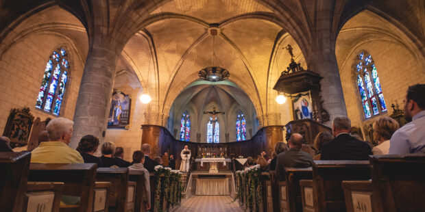 Intérieur d'une église avec fidèles et autel.