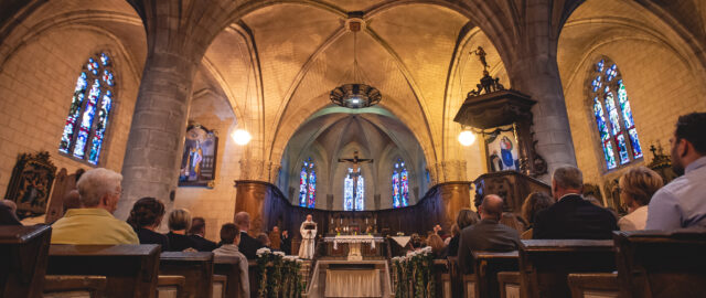 Intérieur d'une église avec fidèles et autel.